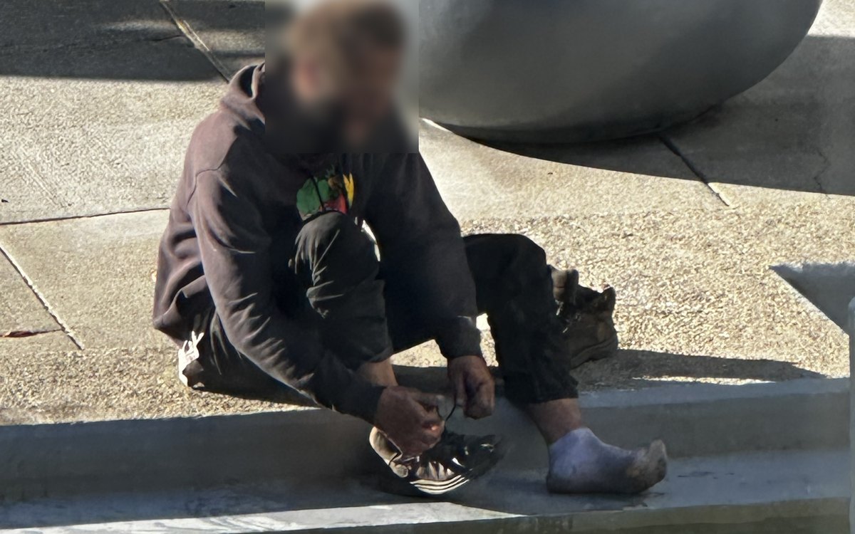 A person at the edge of a public fountain